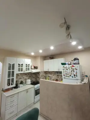 a kitchen with white cabinets and a counter with a refrigerator at Nikolaj in Podgorica
