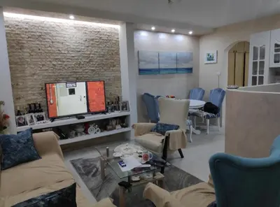 a living room with a tv and a table and chairs at Nikolaj in Podgorica