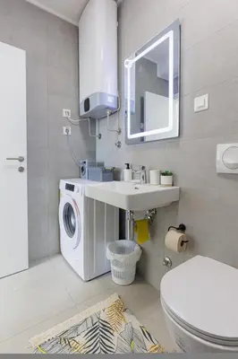 a bathroom with a washing machine and a sink at OLIVA apartment BAR in Bar