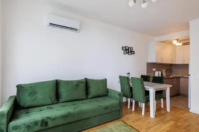 a living room with a green couch and a table at OLIVA apartment BAR in Bar