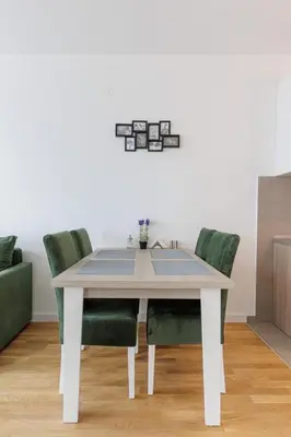 a white dining room table with green chairs at OLIVA apartment BAR in Bar