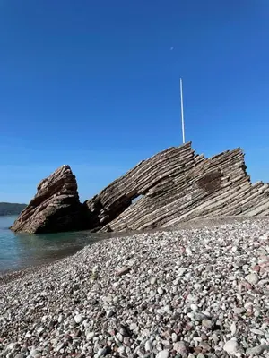 a rocky beach with a large rock formation at Amonte in Budva