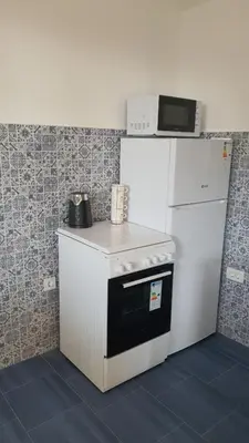 a white refrigerator with a microwave on top of it at Villa Blanca in Bar