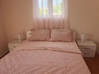 a bedroom with a bed with a pink comforter and a window at Villa Blanca in Bar