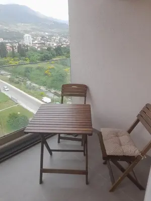 a wooden table and two chairs in front of a window at Apart Anastasija in Bar