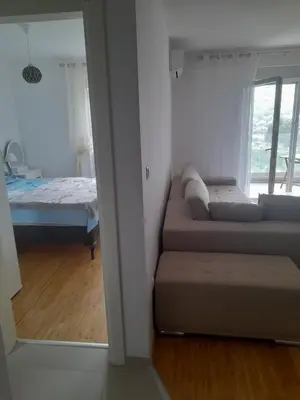 a bedroom with a bed and a couch and a window at Apart Anastasija in Bar