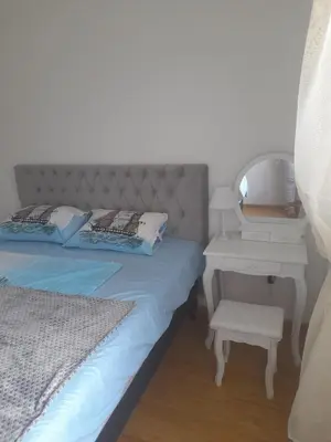 a bedroom with a bed and a table with a mirror at Apart Anastasija in Bar