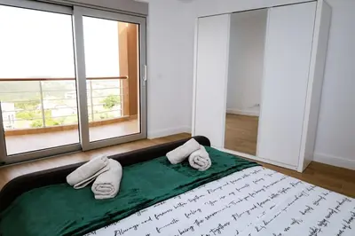 a bedroom with a large bed with towels on it at Penthouse TivatHeights Pool & Sea View-B4 in Kavač