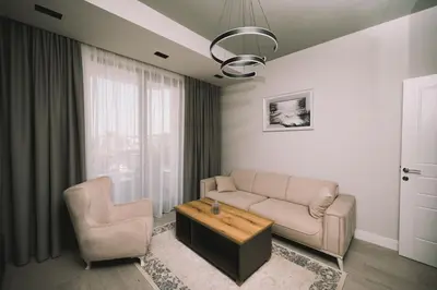 a living room with a couch and a table and a chair at Apartments Moon White Lux in Ulcinj