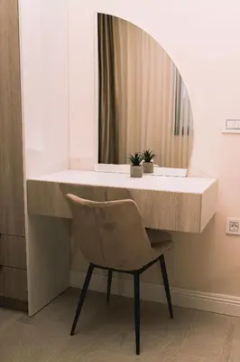 a dressing table with a chair and a mirror at Apartments Moon White Lux in Ulcinj