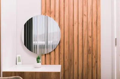 a mirror on a wooden wall next to a table at Apartments Moon White Lux in Ulcinj
