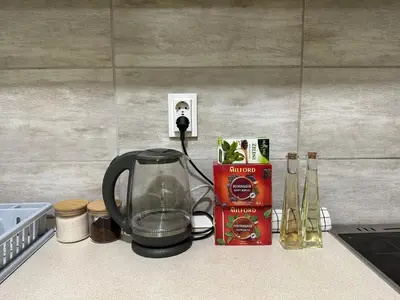 a kitchen counter with a coffee pot and a box at Nikki’s Apartment Podgorica in Podgorica