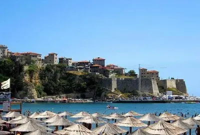 a group of umbrellas on a beach next to a city at Vila Almas in Ulcinj