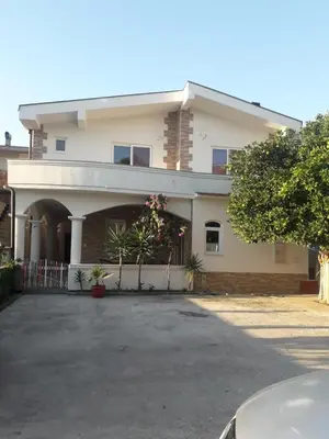 a large white house with a driveway in front of it at Vila Almas in Ulcinj