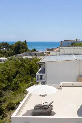 a white umbrella sitting on top of a roof at Higo Apartments in Ulcinj
