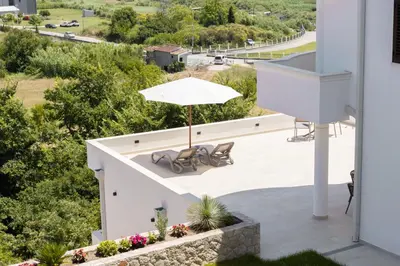 a patio with a table and an umbrella at Higo Apartments in Ulcinj