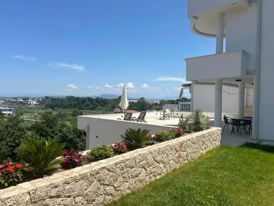 a view of a house with a stone retaining wall at Higo Apartments in Ulcinj