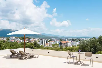 a patio with a table and chairs and an umbrella at Higo Apartments in Ulcinj