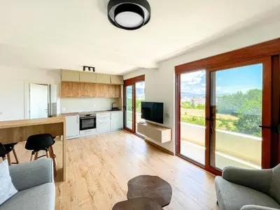 a kitchen and living room with a large window at Higo Apartments in Ulcinj