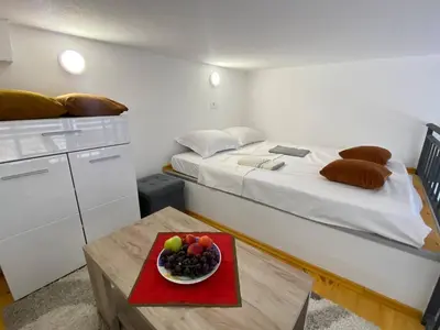 a room with a bed and a bowl of fruit on a table at Sutorange in Sutomore