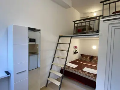 a small bedroom with a bunk bed and a ladder at Sutorange in Sutomore