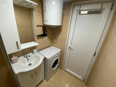 a small bathroom with a washing machine and a sink at Sutorange in Sutomore