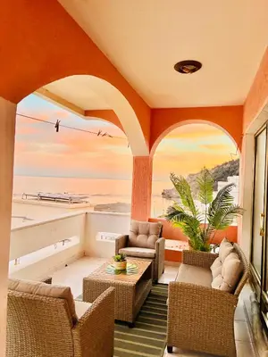 a room with chairs and tables and a view of the ocean at Waves View in Ulcinj