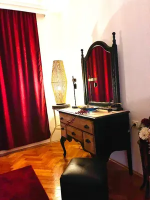 a room with a dresser with a mirror and red curtains at Waves View in Ulcinj
