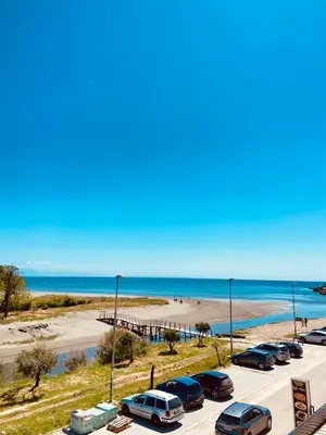 a parking lot next to a beach with cars parked at Waves View in Ulcinj