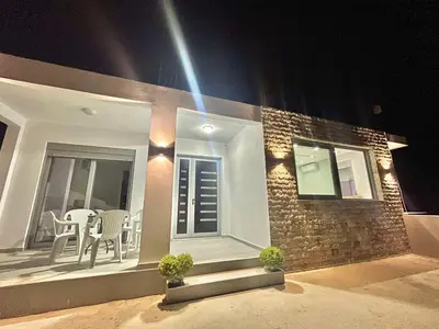 a house with a balcony with a table and chairs at NESI Apartments in Ulcinj