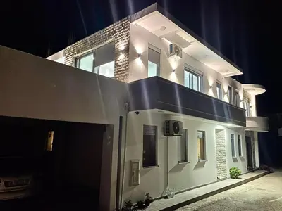 a large white building with lights on it at night at NESI Apartments in Ulcinj