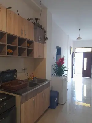 a kitchen with wooden cabinets and a sink at Ulpiana - Apartments,Rooms,Hostel in Ulcinj