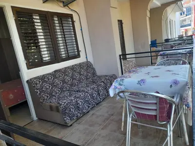 a couch and a table and chairs on a balcony at Ulpiana - Apartments,Rooms,Hostel in Ulcinj