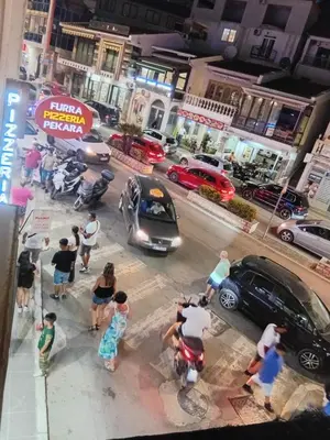 a group of people standing on a city street with cars at Ulpiana - Apartments,Rooms,Hostel in Ulcinj