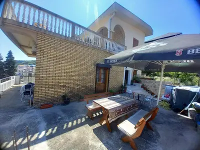 a patio with a table and chairs and an umbrella at Ulpiana - Apartments,Rooms,Hostel in Ulcinj