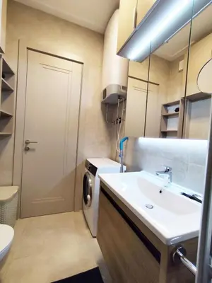 a bathroom with a sink and a washing machine at Azure Horizon in Becici
