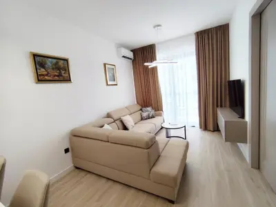 a living room with a couch and a tv at Azure Horizon in Becici