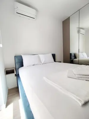 a bedroom with a large white bed and a mirror at Azure Horizon in Becici