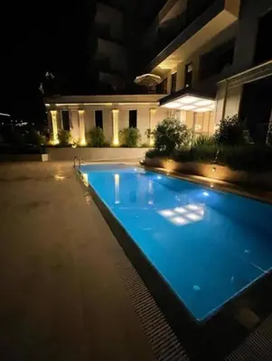 a swimming pool in front of a building at night at Azure Horizon in Becici