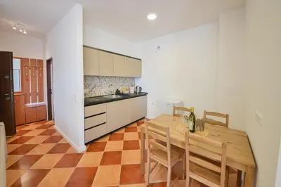 a kitchen and dining room with a wooden table at Harmonia Hills Apartments in Budva