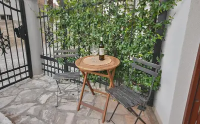a table with a bottle of wine and two chairs at Harmonia Hills Apartments in Budva