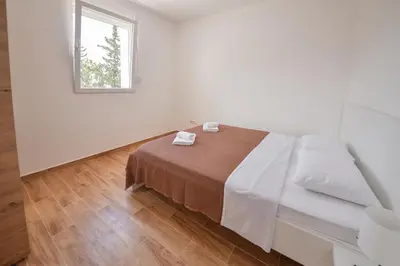 a white room with a bed and a window at Harmonia Hills Apartments in Budva
