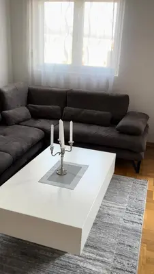 a living room with a couch and a table with candles at Apartment Shine in Konik