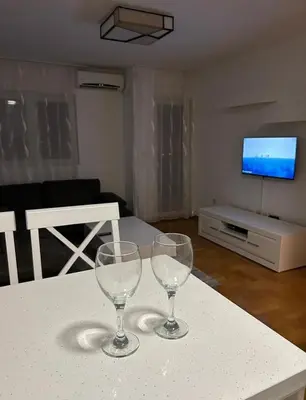 two wine glasses sitting on a table in a living room at Apartment Shine in Konik