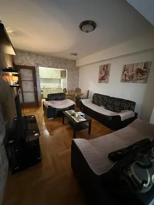a living room with two couches and a table at Big apartment 2 in Podgorica