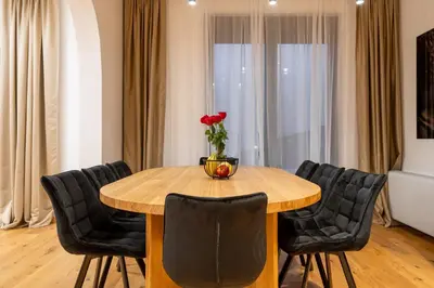 a dining room table with chairs and a vase of flowers on it at White Hill Villa in Masline