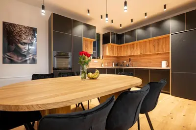 a kitchen with a wooden table and black cabinets at White Hill Villa in Masline