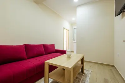 a living room with a red couch and a table at Reis Apartments in Ulcinj