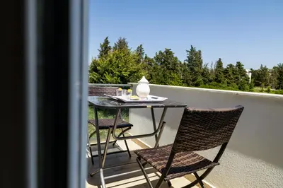 a table with chairs and a vase on it on a balcony at Reis Apartments in Ulcinj