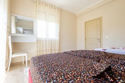 a bedroom with a bed with a colorful blanket on it at Reis Apartments in Ulcinj